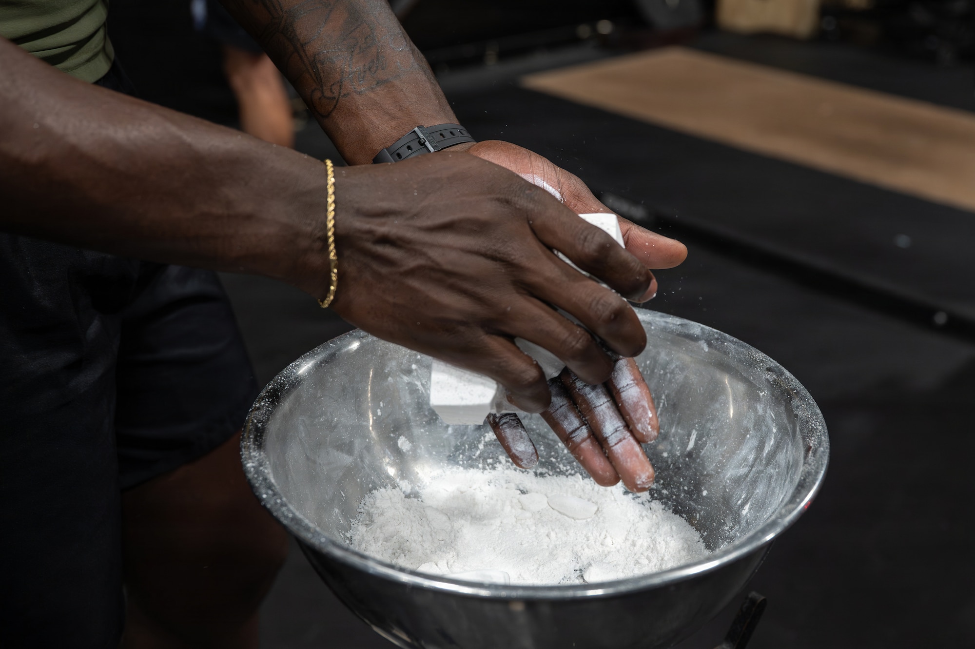 U.S. Air Force Airman 1st Class James Coriolan, 35th Security Forces Squadron response force member, applies chalk to his hands before competing in a challenge during Misawa’s Strongest 100 competition at Misawa Air Base, Japan, Aug. 22, 2026. The competition pushed participants beyond their everyday fitness routines, testing the strength, endurance and resilience essential to maintaining a physically fit force ready to defend Japan from adversaries. (U.S. Air Force photo by Airman 1st Class Angelica Winther)