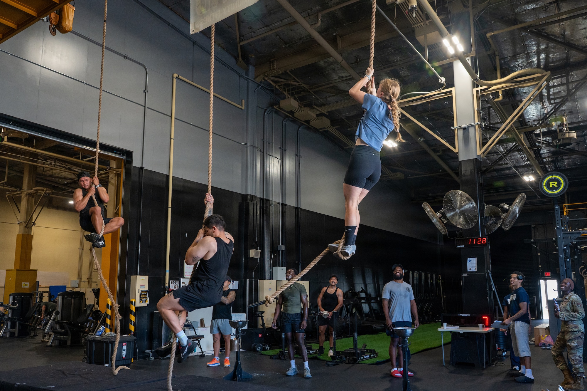 From left, U.S. Air Force Senior Airman David Jeffrey, 35th Communications Squadron radio frequency transmission systems technician, Staff Sgt. Alberto Rosendo-Diaz, 35th Security Forces Squadron military working dog handler, and military spouse Samantha Willenbrok compete in a rope climb during Misawa’s Strongest 100 competition at Misawa Air Base, Japan, Aug. 22, 2026. The event brought members of the Misawa Air Base community together through challenging competition, fostering camaraderie and a shared commitment to fitness that supports a ready and connected joint and bilateral military community responsible for defending Japan from adversaries. (U.S. Air Force photo by Airman 1st Class Angelica Winther)