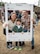 A family, made up of a mom, dad and a toddler boy pose for a photo, holding an Instagram frame sign