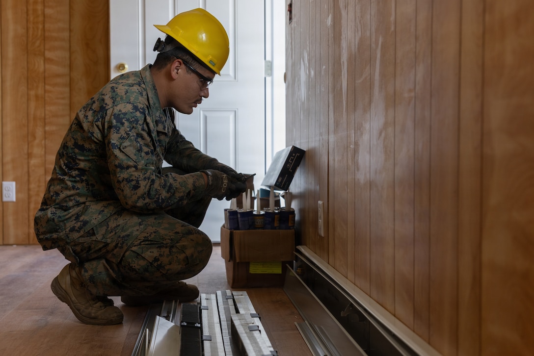 U.S. Marine Corps Sgt. Henry Sanchezzuniga, a team leader with 6th Engineer Support Battalion, Force Headquarters Group, Marine Forces Reserve, fixes an outlet during Operation Arctic Shelter, Beaver, Alaska, Aug. 13, 2026. Operation Arctic Shelter is an Innovative Readiness Training mission partnered with the Interior Regional Housing Authority to build affordable housing, providing Marines with critical vertical and horizontal construction training in a cold-weather environment. (U.S. Marine Corps photo by Lance Cpl. Claire Cheney)