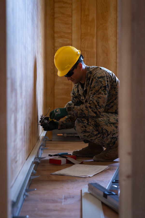 U.S. Marine Corps Sgt. Jacob Garza, a squad leader with 6th Engineer Support Battalion, Force Headquarters Group, Marine Forces Reserve, fixes an outlet during Operation Arctic Shelter, Beaver, Alaska, Aug. 13, 2026. Operation Arctic Shelter is an Innovative Readiness Training mission partnered with the Interior Regional Housing Authority to build affordable housing, providing Marines with critical vertical and horizontal construction training in a cold-weather environment. (U.S. Marine Corps photo by Lance Cpl. Claire Cheney)