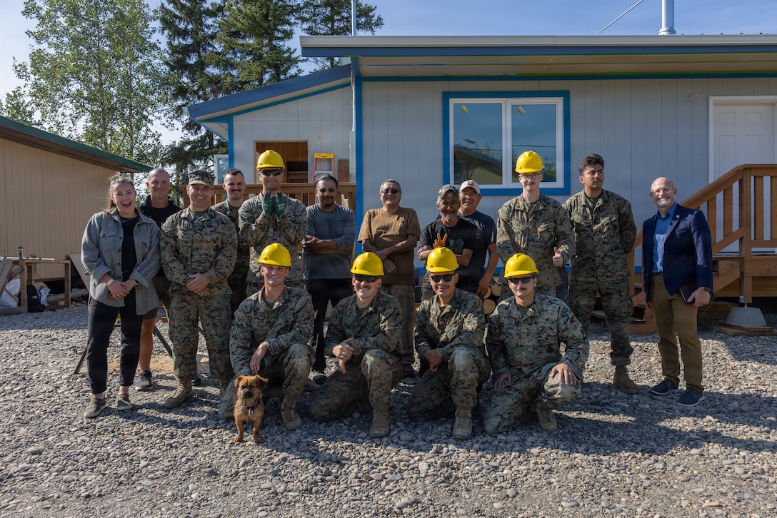 U.S. Marines with 6th Engineer Support Battalion, residents, and representatives from the Interior Regional Housing Authority gather for a group photo at an Operation Arctic Shelter build site in Beaver, Alaska, Aug. 13, 2026. Operation Arctic Shelter is an Innovative Readiness Training mission partnered with the Interior Regional Housing Authority to build affordable housing, providing Marines with critical vertical and horizontal construction training in a cold-weather environment. (U.S. Marine Corps photo by Lance Cpl. Claire Cheney)