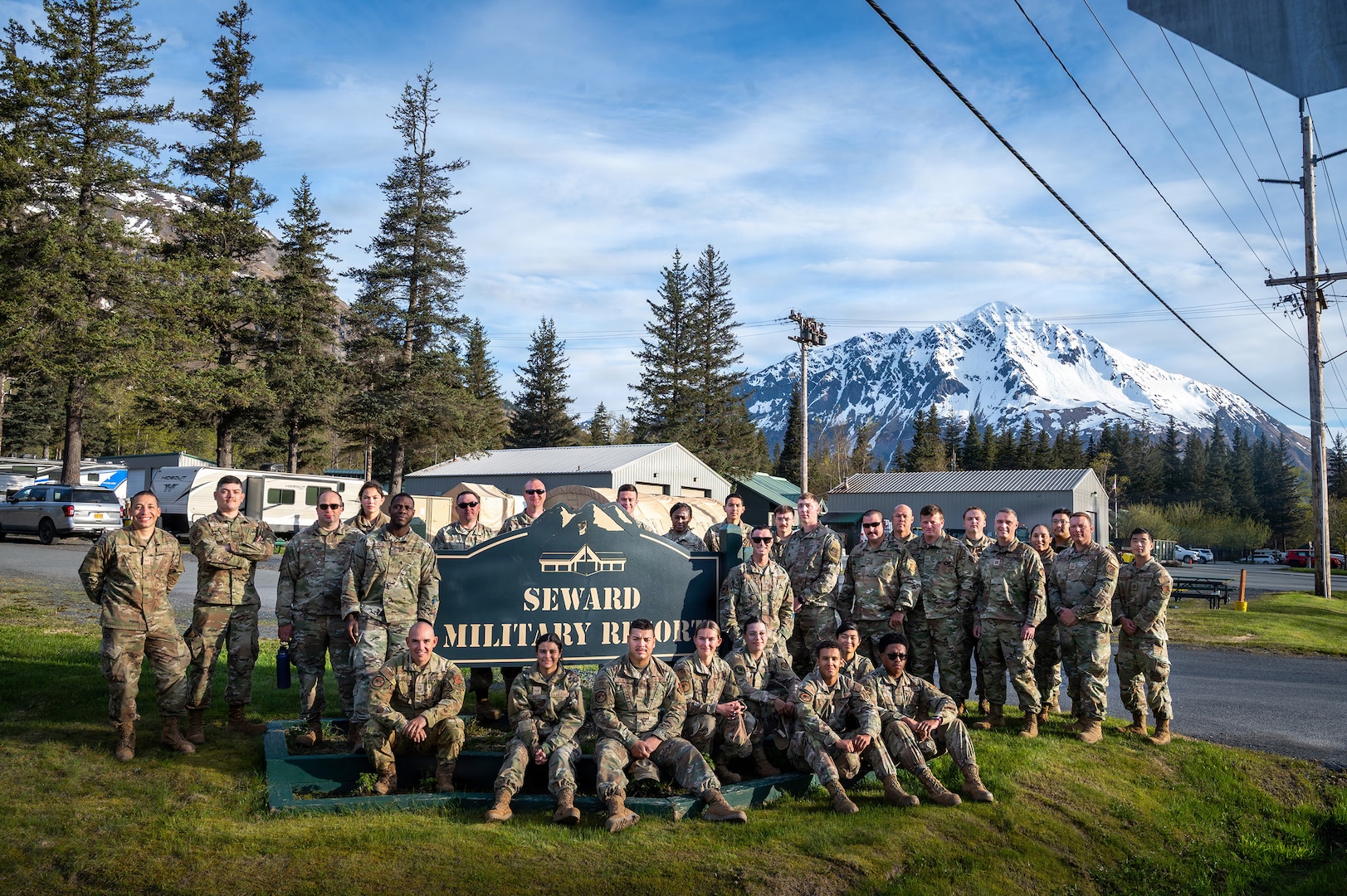 U.S. Air National Guard members of 103d Civil Engineering Squadron pose in front of a sign for Seward Military Resort, where they worked on multiple construction and electrical projects during during a two week National Guard Bureau deployment for training in Seward, Alaska, June 2, 2026.