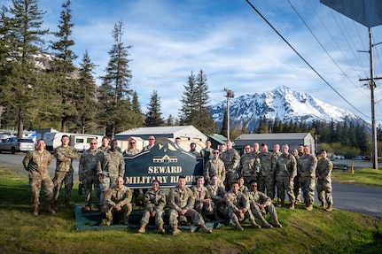 U.S. Air National Guard members of 103d Civil Engineering Squadron pose in front of a sign for Seward Military Resort, where they worked on multiple construction and electrical projects during during a two week National Guard Bureau deployment for training in Seward, Alaska, June 2, 2026.