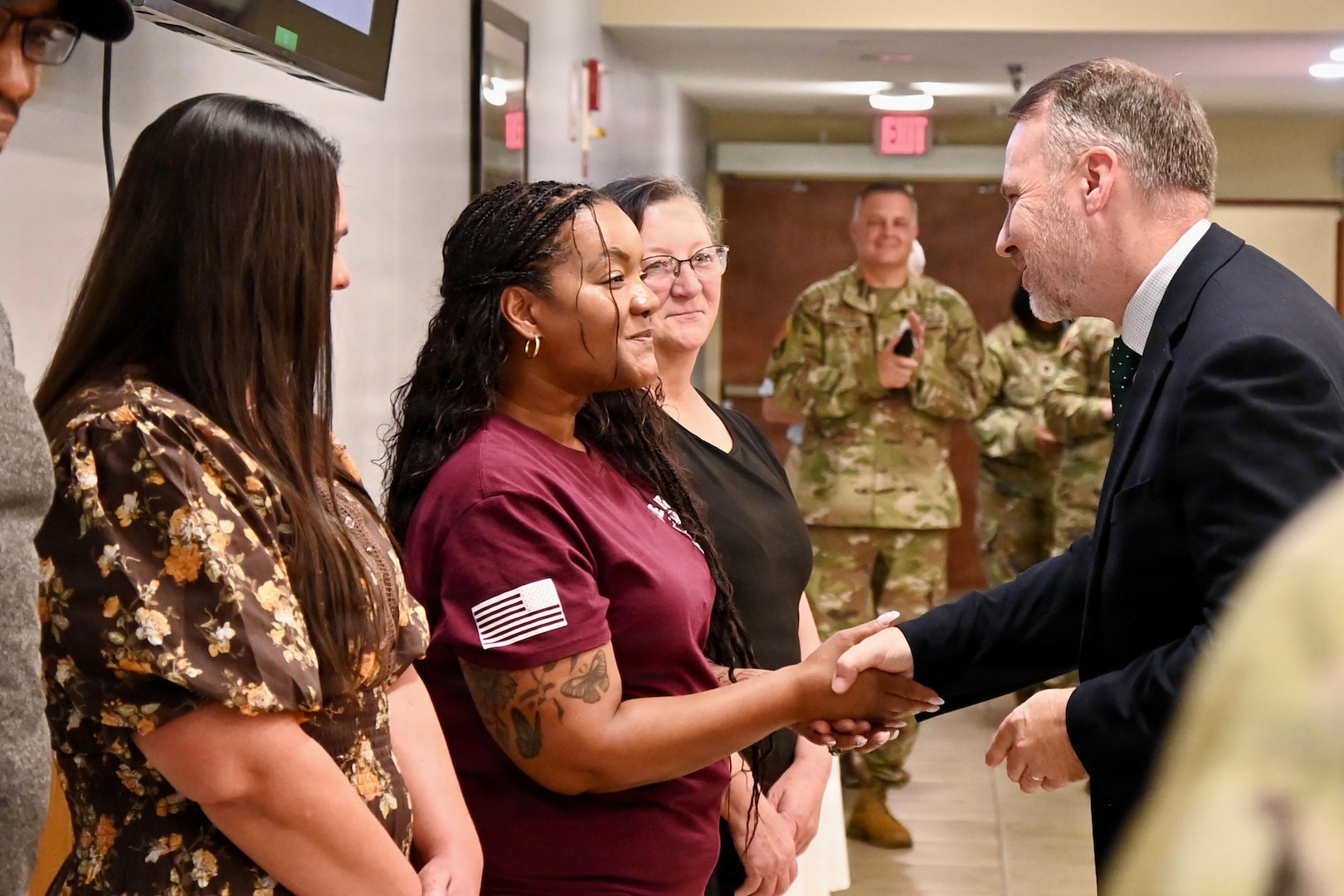 Senior Executive Service member gives a BJACH  employee a command coin for her dedication and contributions to the organization.