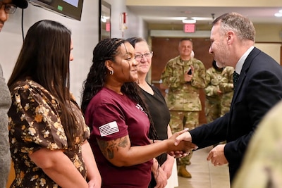 Senior Executive Service member gives a BJACH  employee a command coin for her dedication and contributions to the organization.