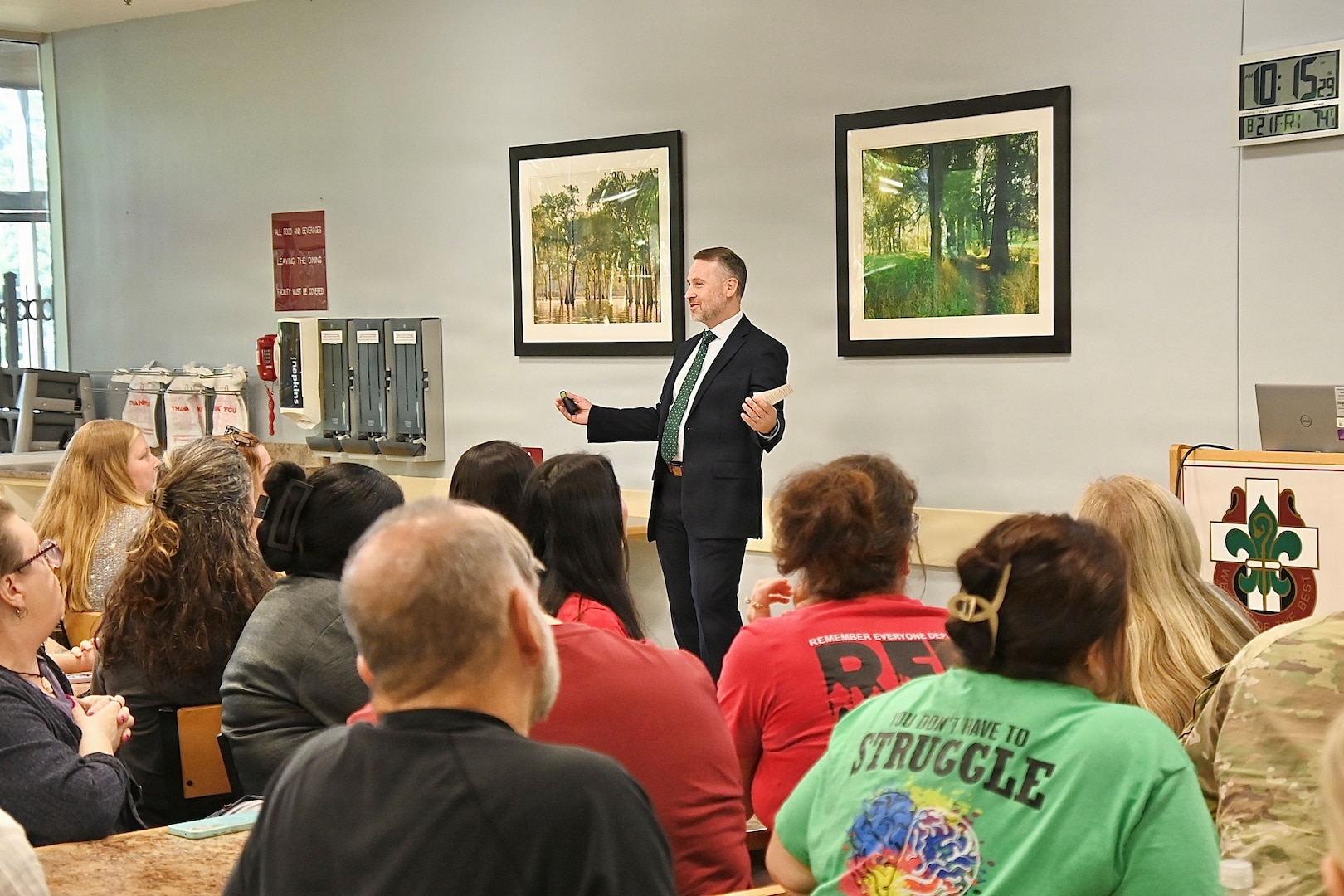 A senior executive leader speaks to a group of BJACH employees gathered in the Dining Facility.during a visit to the Hospital.