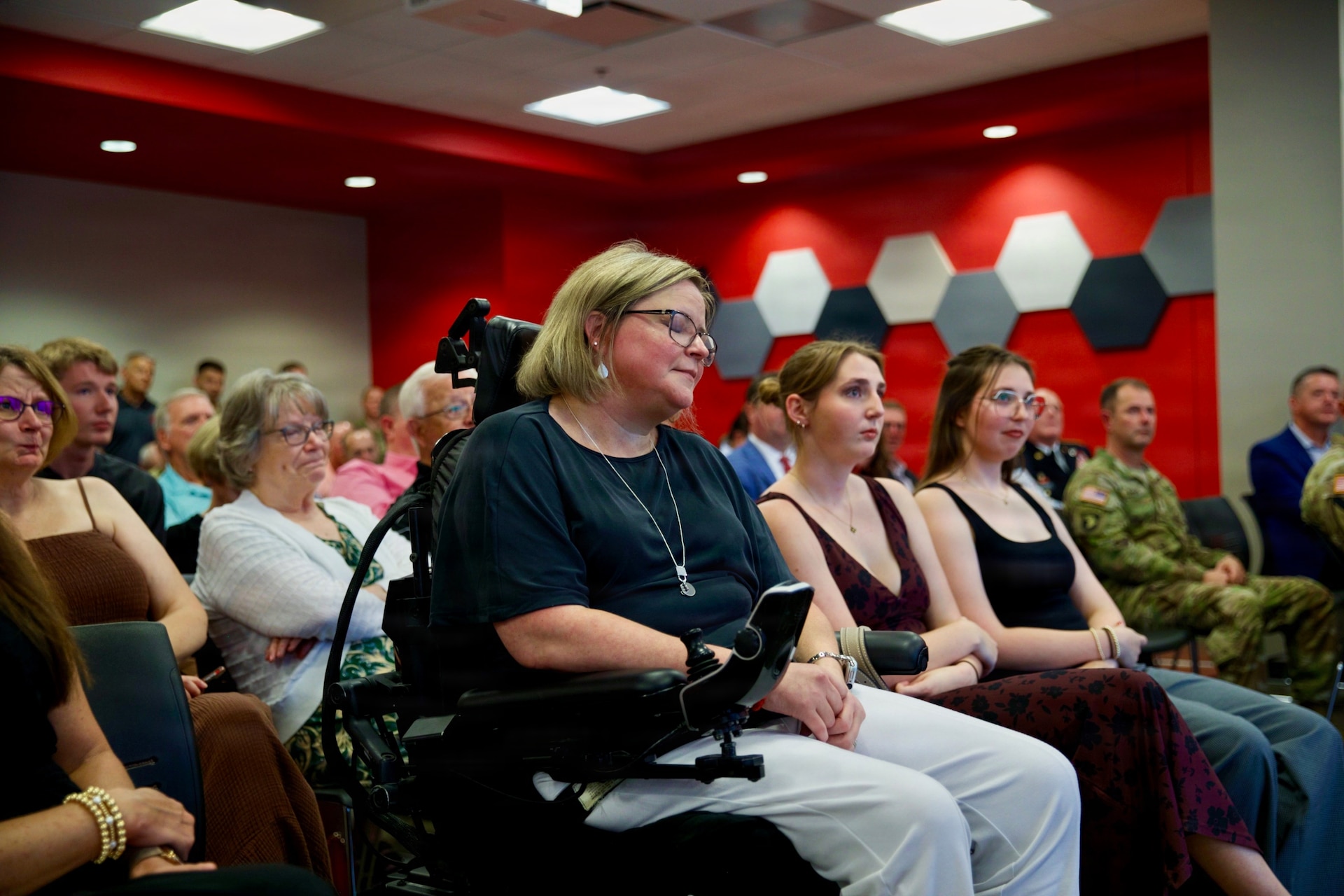 Gretchen Armstrong, left, along with daughters Anna, center, and Emma, watch as Brig. Gen. Michael Armstrong delivers remarks during his promotion ceremony at Western Kentucky University in Bowling Green, Kentucky, Aug. 23, 2026.