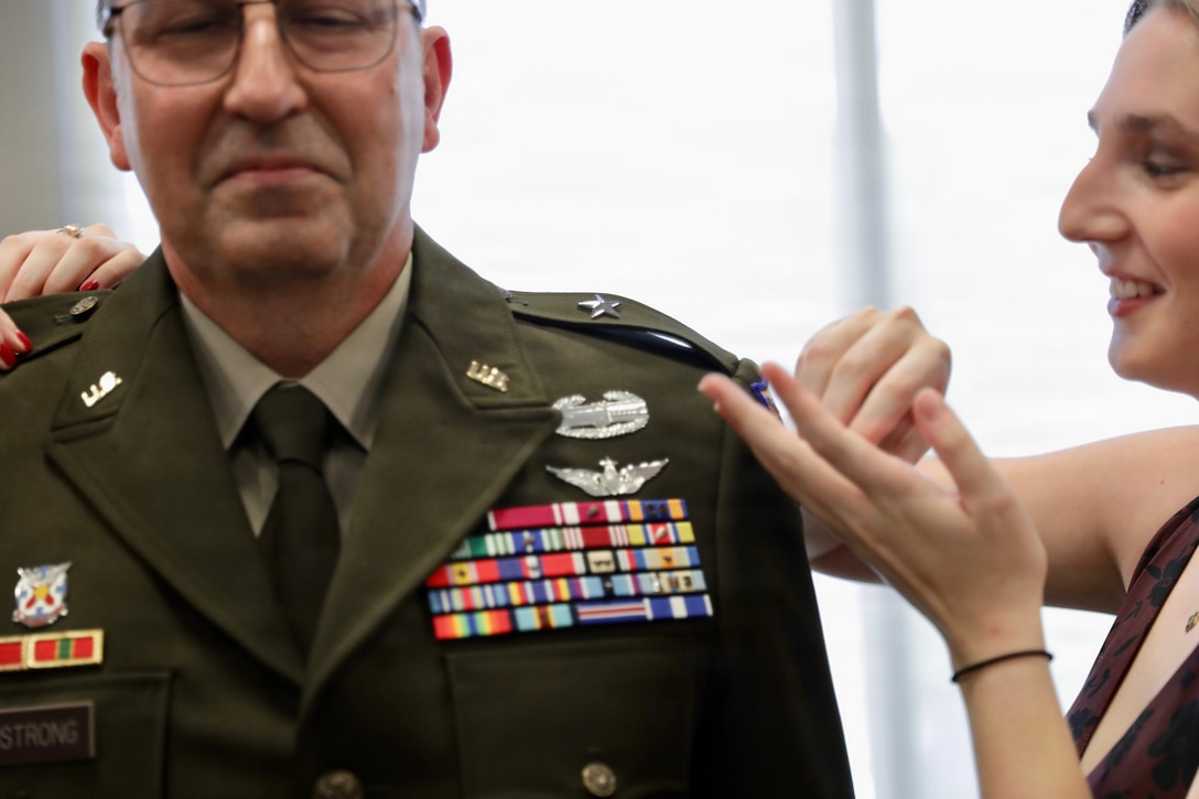 Anna Armstrong pins the rank insignia of brigadier general onto the shoulders of her father, Col. Michael Armstrong, during a promotion ceremony at Western Kentucky University in Bowling Green, Kentucky, Aug. 23, 2026.