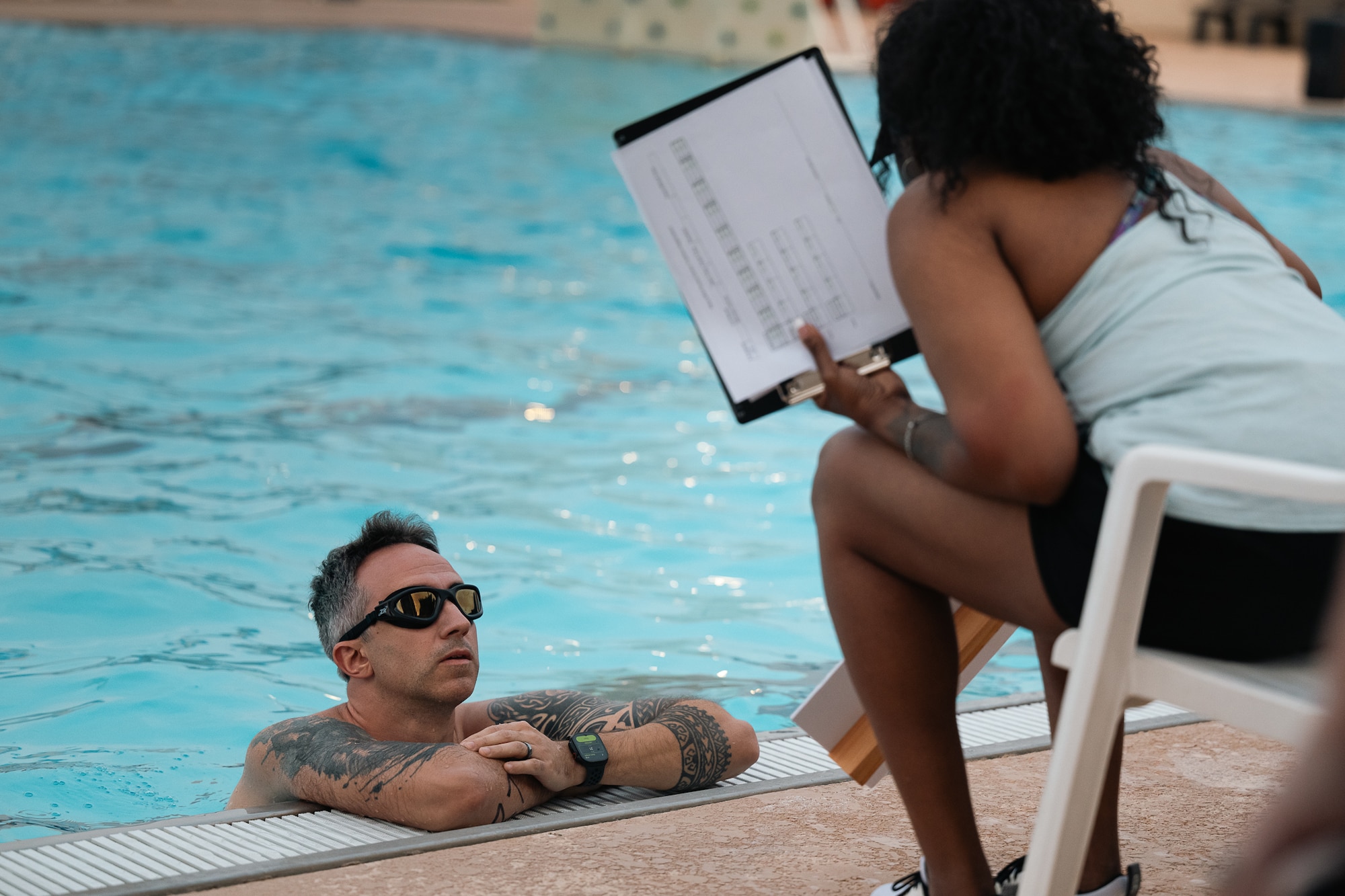An athlete listens to swim instructions during a sprint triathlon at Altus Air Force Base, Oklahoma, Aug. 22, 2026. The swim portion set the pace for competitors before they transitioned to the cycling and running portions of the event. (U.S. Air Force photo by Senior Airman Jonah Bliss)