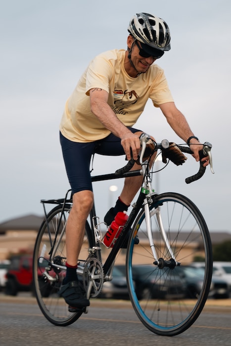 An athlete rides his bike during a sprint triathlon at Altus Air Force Base, Oklahoma, Aug. 22, 2026. Following the swim, competitors completed a 20-kilometer cycling course before moving on to the final leg of the triathlon. (U.S. Air Force photo by Senior Airman Jonah Bliss)