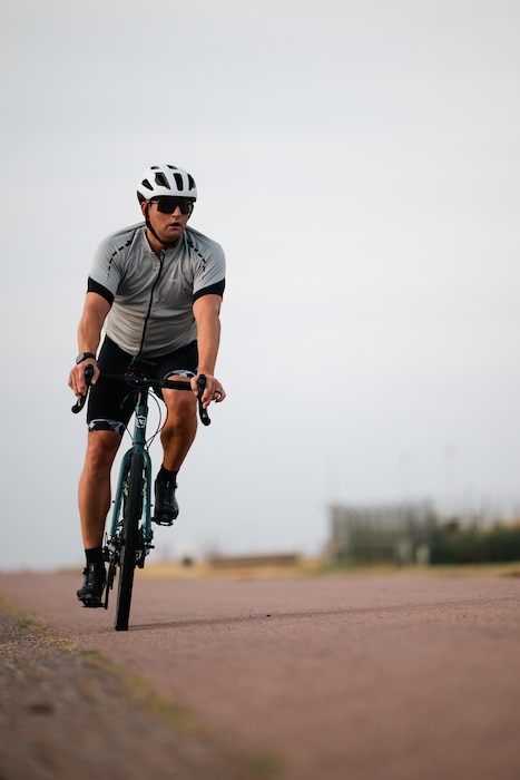 An athlete rides his bike during a sprint triathlon at Altus Air Force Base, Oklahoma, Aug. 22, 2026. The triathlon gave participants an opportunity to test their physical fitness outside of traditional fitness activities while competing alongside fellow members of the installation community. (U.S. Air Force photo by Senior Airman Jonah Bliss)