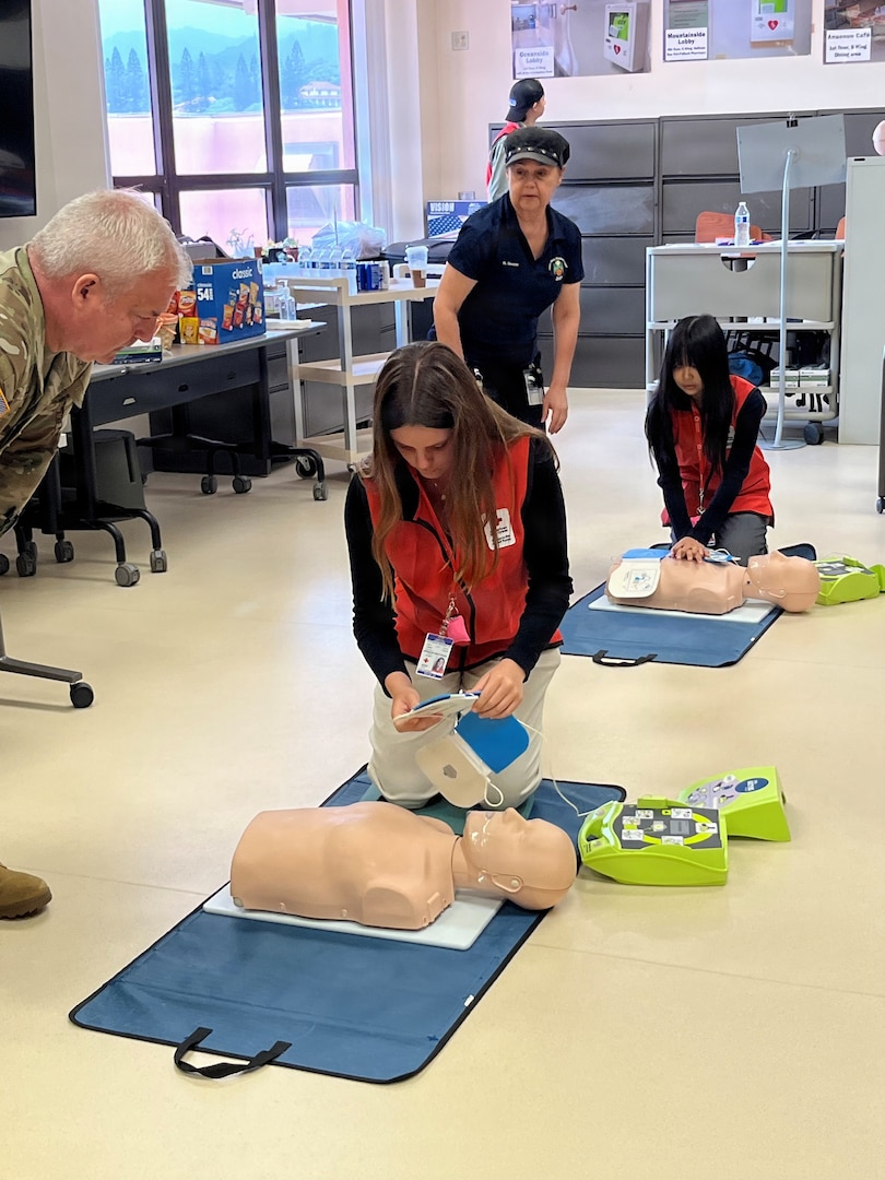 U.S. Army Lt. Col. Daniel Hines, assistant director of Tripler Army Medical Center’s certified nurse training program, and Vivienne Edwards, TAMC’s Rehabilitation Therapy Service manager, give cardiopulmonary resuscitation training to VolunTEENs Catherine O’Connor and Keighley De Los Reyes in Tripler Army Medical Center’s Department of Hospital Education and Training.