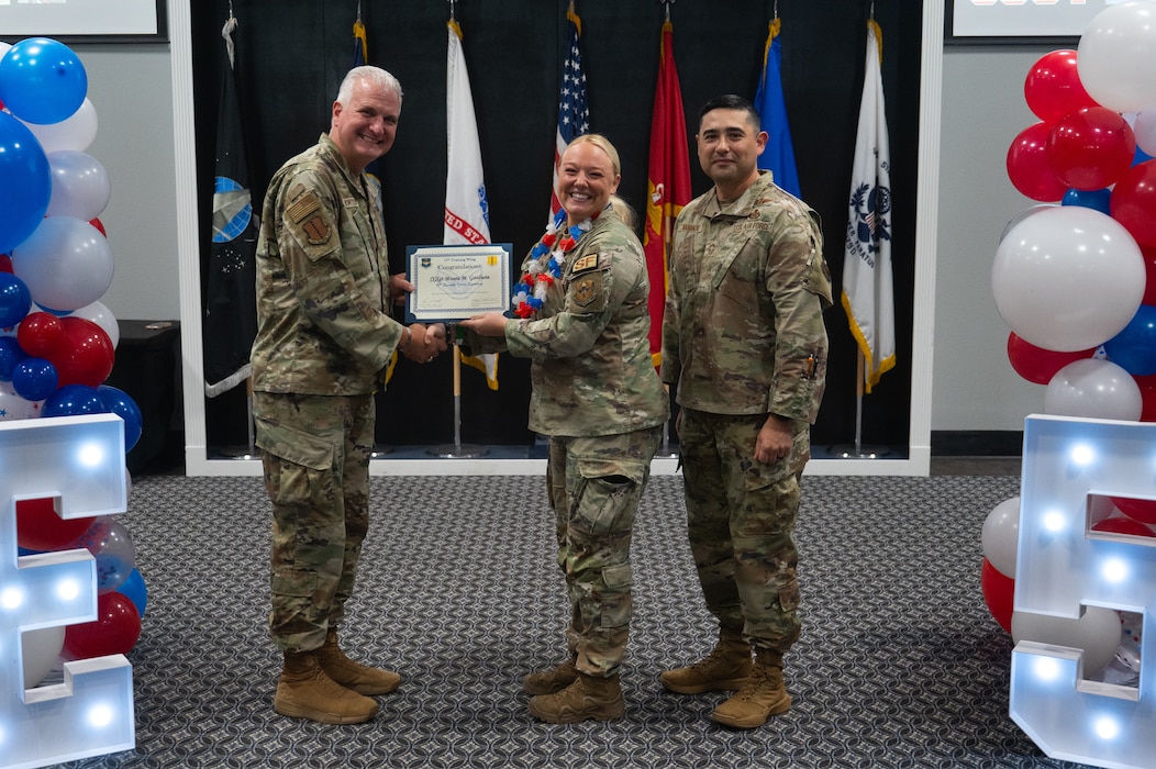 U.S. Air Force Col. Matthew Norton, 17th Training Wing commander, and Chief Master Sgt. Marcus Naranjo, 17th Training Group senior enlisted leader, present Senior Airman Maura Goodwin, 17th Security Forces Squadron military working dog handler, with her staff sergeant select certificate during a staff sergeant release party at Goodfellow Air Force Base, Texas, Aug. 21, 2026. Promotion to staff sergeant marks a pivotal point in an Airman’s career where they transition from developing supervisory and leadership skills to applying those new skills as a frontline supervisor and noncommissioned officer. (U.S. Air Force photo by Senior Airman Brian Lummus)