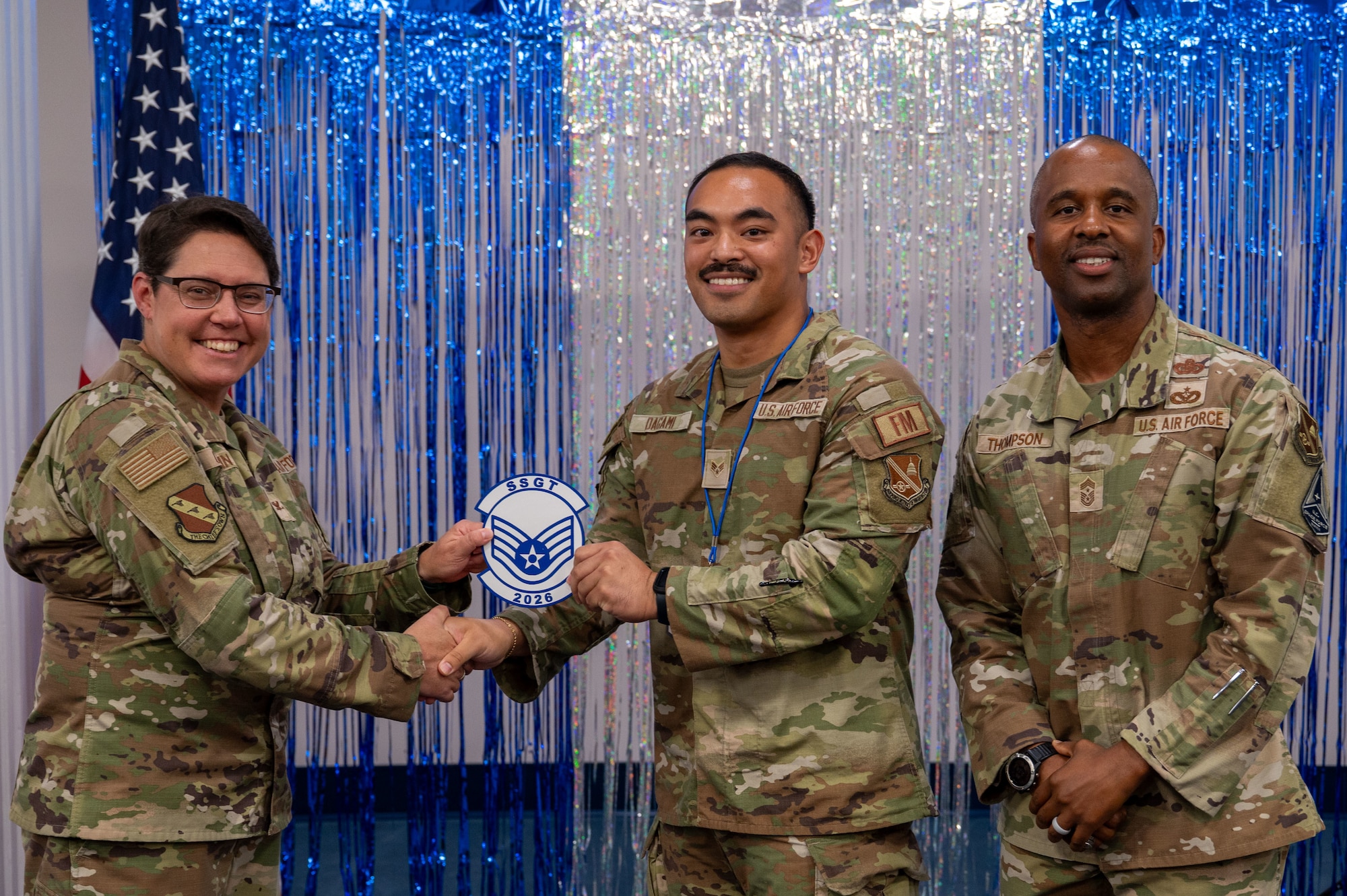 U.S. Air Force Senior Airman Andrew Dagami, center, budget analyst for the 11th Comptroller Squadron, receives a memento from Col. Rebecca Corbin, left, deputy commander of Joint Base Anacostia-Bolling and the 11th Wing, and Chief Master Sgt. Anthony Thompson Jr., senior enlisted leader for JBAB and 11th Wing command chief.