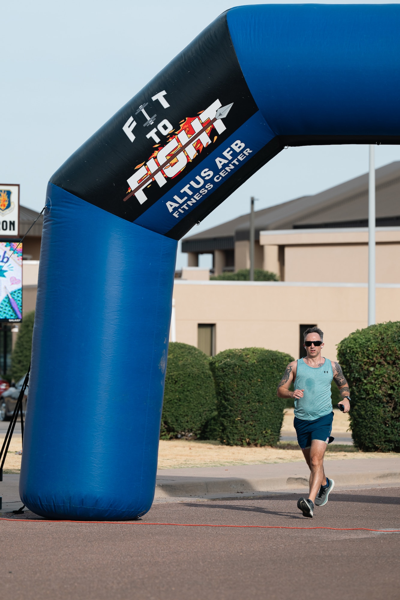 An athlete crosses the finish line during a sprint triathlon at Altus Air Force Base, Oklahoma, Aug. 22, 2026. Participants who completed the event were recognized for their achievement with a commemorative belt buckle. (U.S. Air Force photo by Senior Airman Jonah Bliss)