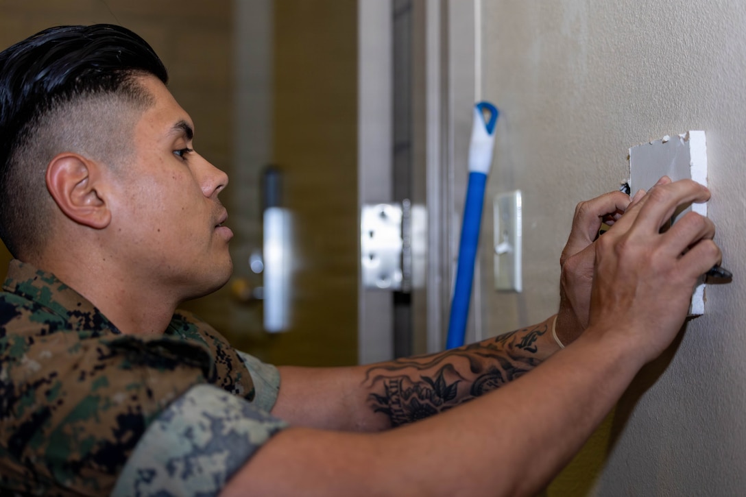 U.S. Marine Corps Pfc. Jesus F. Sanchez, an administrative specialist with Alpha Company, Headquarters and Support Battalion, Marine Corps Installations West, patches drywall during Operation Clean Sweep IV at Marine Corps Base Camp Pendleton, Calif., April 7, 2026. OCS IV, part of the ongoing Barracks 360 Reset initiative, demonstrates a collective commitment to improving living conditions through shared ownership, sustained accountability and measurable improvements to barracks habitability. (U.S. Marine Corps photo by Cpl. Adrian Estrada)
