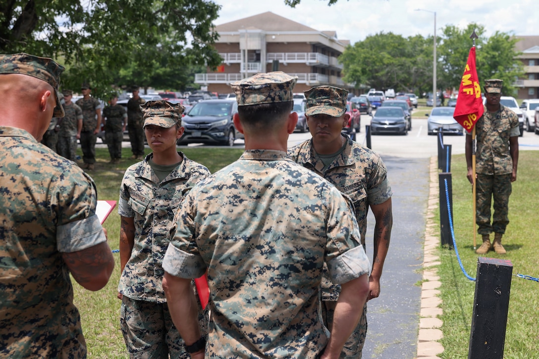 U.S. Marine Corps Cpl. Emily Martinez, left, a transmissions system operator, and Cpl. Johnny Tamayo, a ground electronics transmission systems maintainer, both with 3rd Battalion, 6th Marine Regiment, 2nd Marine Division, stand at attention during an award ceremony on Marine Corps Base Camp Lejeune, June 25, 2026. The Marines were recognized and awarded for their actions in rendering aid to a victim of a shooting in Wilmington, North Carolina. (U.S. Marine Corps photo by Cpl. Jesse Davis)