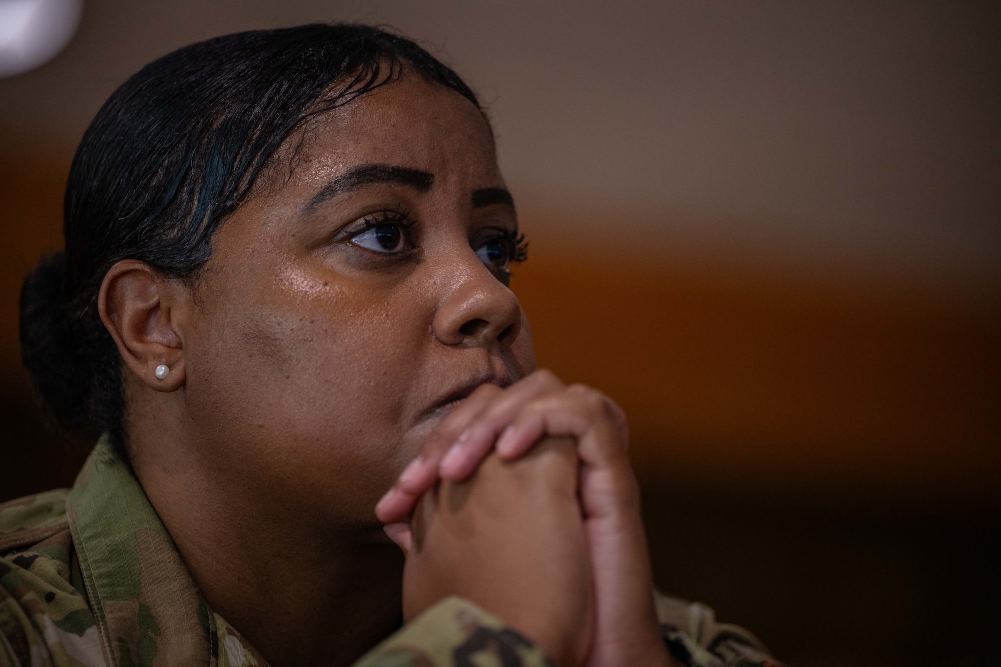 a woman wearing OCPs with her hands folded in front of her looks straight ahead