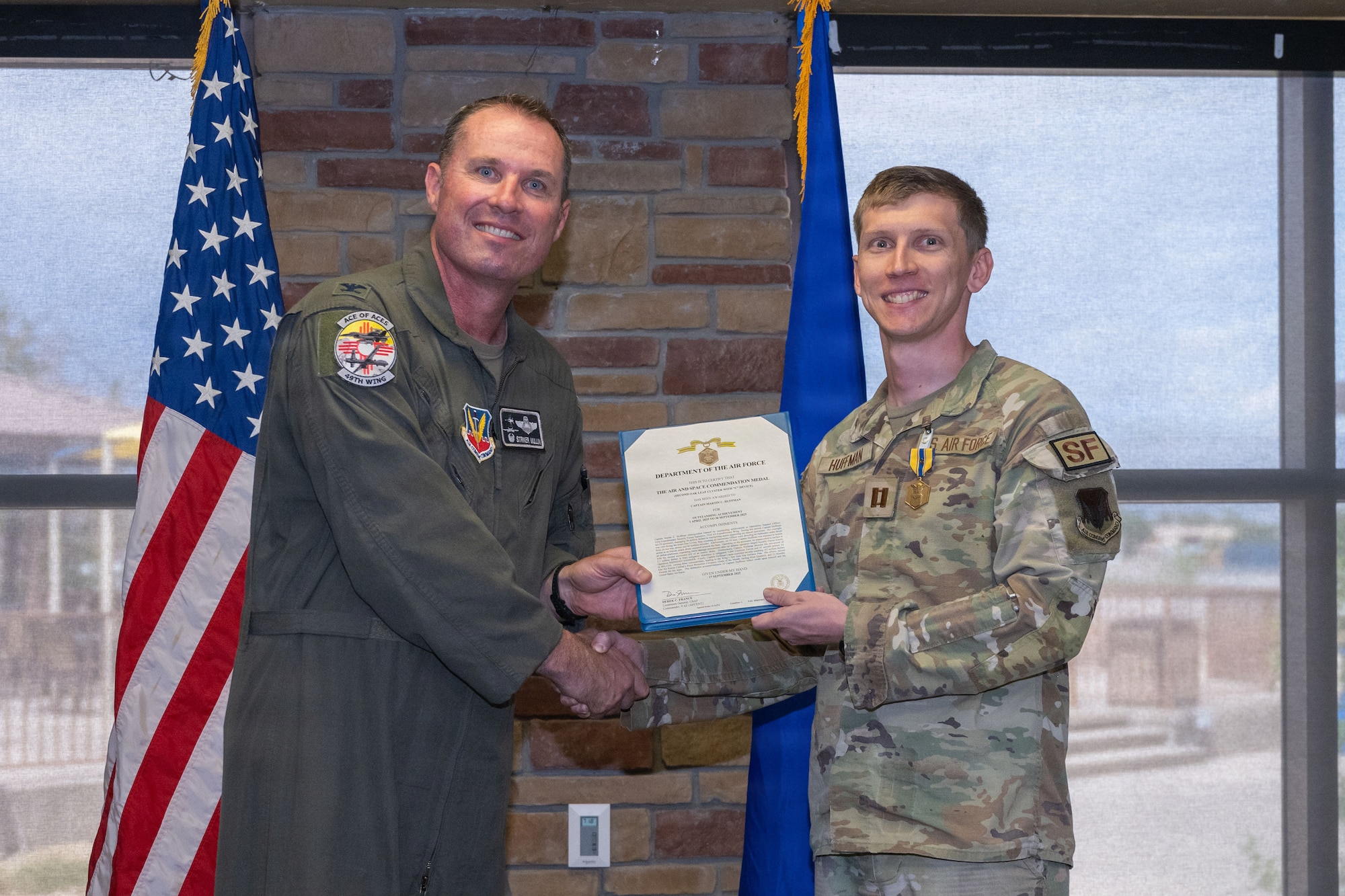 U.S. Air Force Capt. Martin Huffman, 49th Security Forces Squadron operations officer, right, receives the Air and Space Commendation Medal with Second Oak Leaf Cluster and Combat Device during the 49th Wing Security Forces Decoration Ceremony at Holloman Air Force Base, New Mexico, July 10, 2026. While deployed, Huffman supported operations in the U.S. Central Command area of responsibility. (U.S. Air Force photo by Airman 1st Class Elijah Strickland)