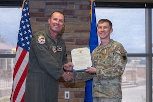U.S. Air Force Capt. Martin Huffman, 49th Security Forces Squadron operations officer, right, receives the Air and Space Commendation Medal with Second Oak Leaf Cluster and Combat Device during the 49th Wing Security Forces Decoration Ceremony at Holloman Air Force Base, New Mexico, July 10, 2026. While deployed, Huffman supported operations in the U.S. Central Command area of responsibility. (U.S. Air Force photo by Airman 1st Class Elijah Strickland)