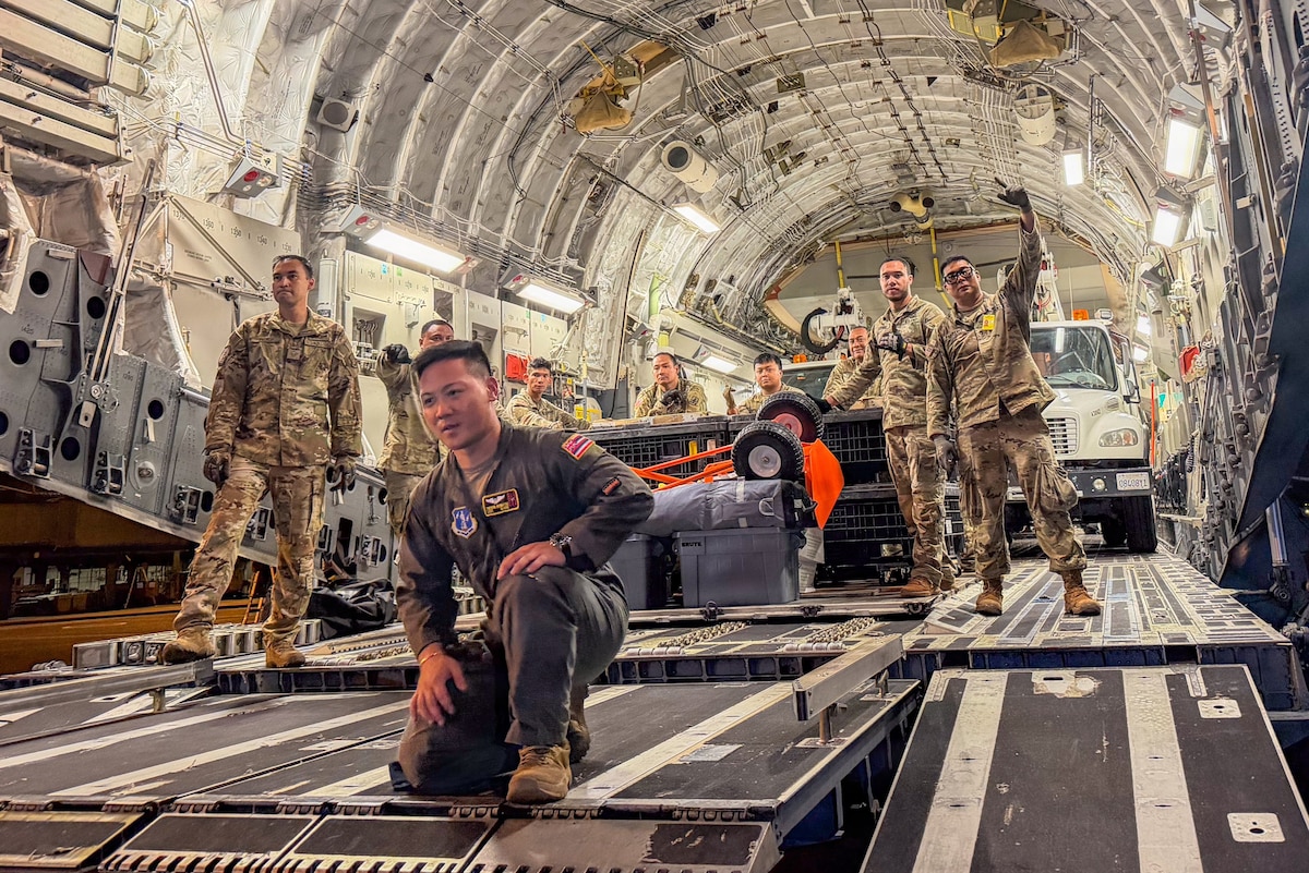 Photo of aircrew and loadmasters working to unload a C-17