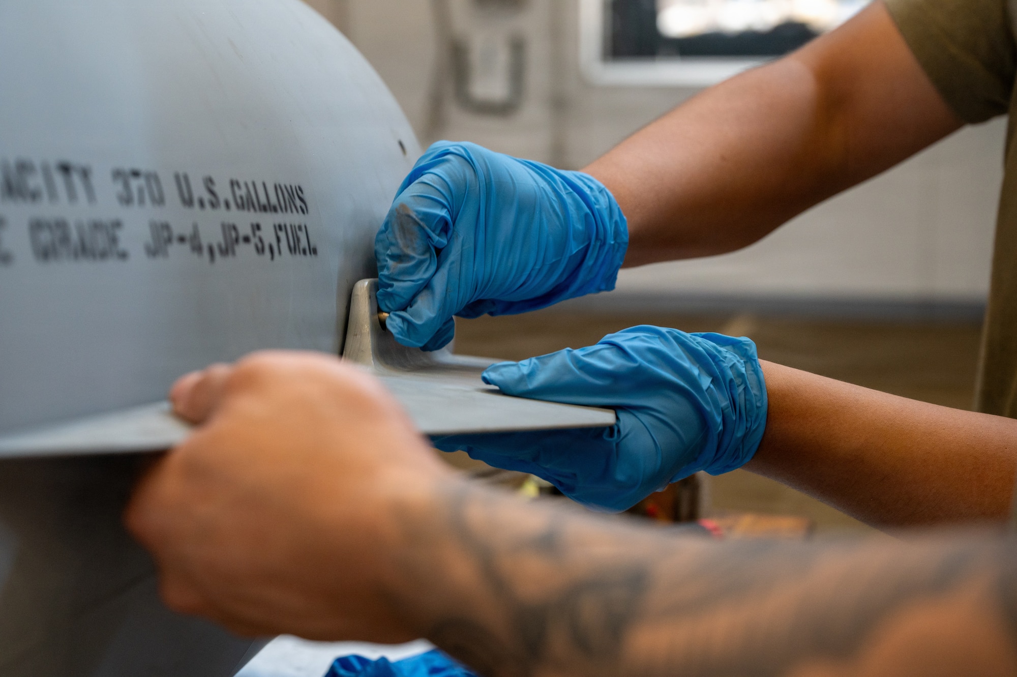 U.S. Air Force Airmen fit a fin onto an external fuel tank during Nestable Fuel Tank Build Up (NFTBU) training at Misawa Air Base, Japan, Aug. 25, 2026. The training builds the multi-capable maintenance force needed to rapidly replenish external fuel tanks and sustain the 35th Fighter Wing’s combat airpower in support of operational demands across the Pacific. (U.S. Air Force photo by Airman 1st Class Angelica Winther)