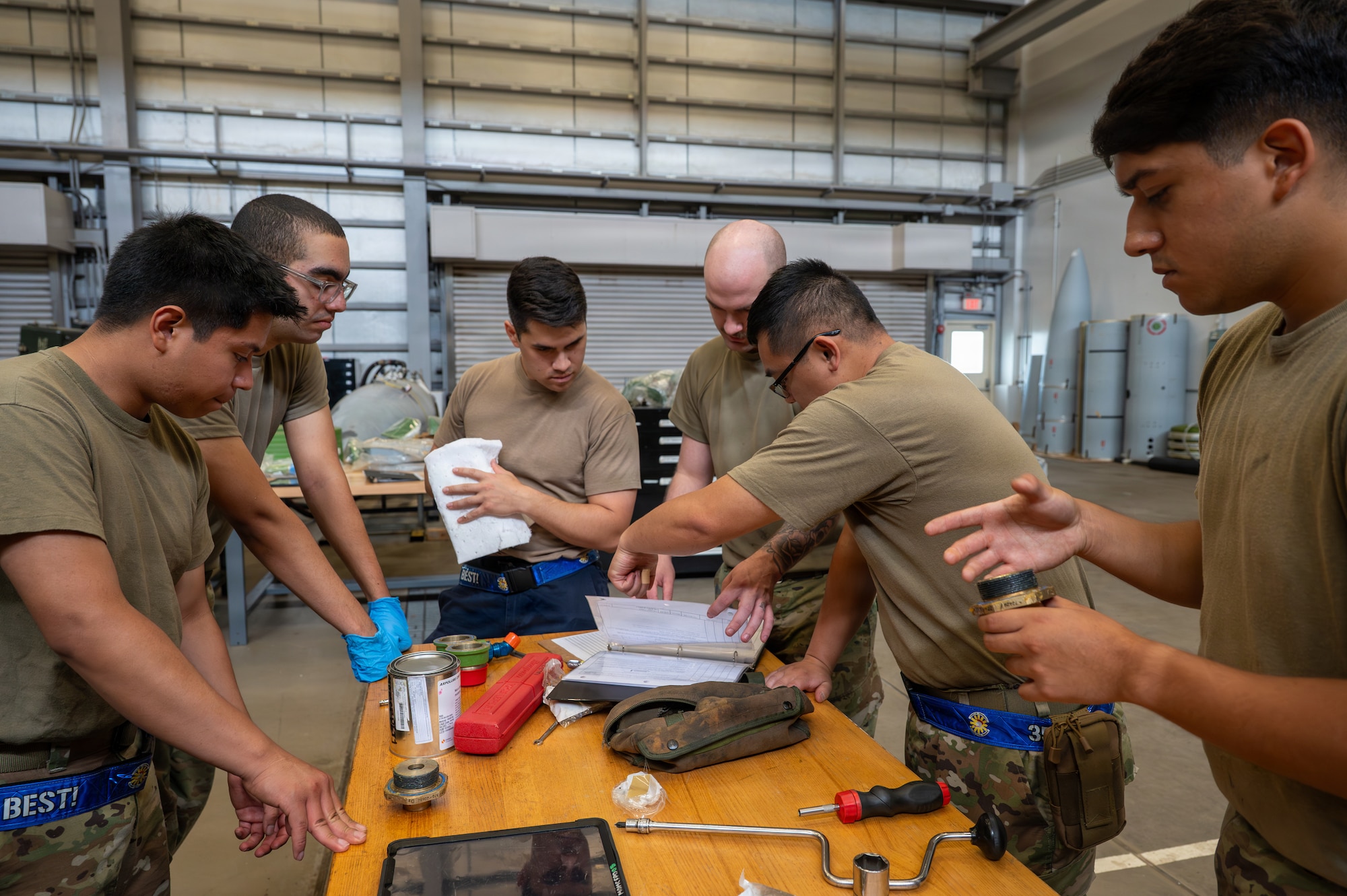 U.S. Air Force Airmen review technical orders while assembling external fuel tank components during Nestable Fuel Tank Build Up (NFTBU) training at Misawa Air Base, Japan, Aug. 26, 2026. Hands-on NFTBU training develops a broader pool of qualified personnel capable of augmenting Fuel Systems, increasing the 35th Fighter Wing’s ability to sustain maintenance operations and generate combat-ready aircraft across the Pacific. (U.S. Air Force photo by Airman 1st Class Angelica Winther)