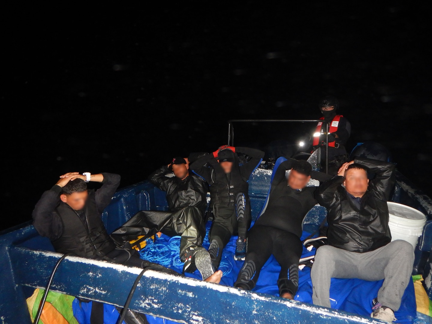 Five suspected drug smugglers in their vessel observed by Coast Guard law enforcement.