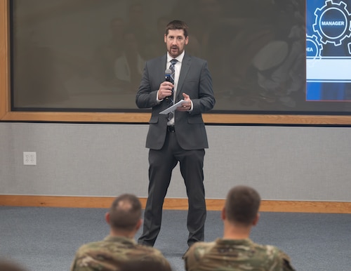 Image of person speaking in a conference room.