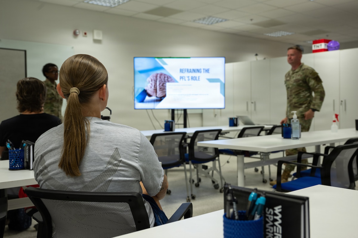 A girl listens to an instructor go over a slide in the peer fitness course