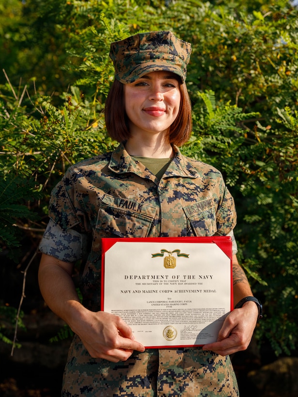 U.S. Marine Corps Cpl. Harleigh Faulk, a combat photographer with Security Battalion, Marine Corps Base Quantico, poses for a photo with her Navy and Marine Corps Achievement Medal on MCB Quantico, Virginia, Aug. 26, 2026. Faulk was awarded a NAM on Aug.10, 2026, for life-saving actions performed on Halloween night, 2025. (U.S. Marine Corps photo by Lance Cpl. Lynsee Avila-Ramirez)