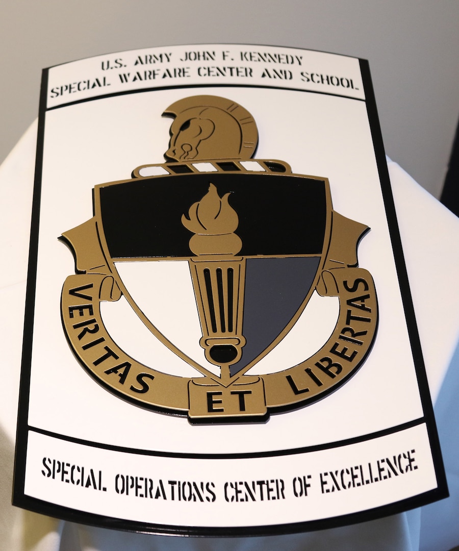 A plaque bearing the U.S. Army John F. Kennedy Special Warfare Center and School crest sits on a table during a ceremony at the John F. Kennedy Presidential Library and Museum in Boston, April 16, 2019.