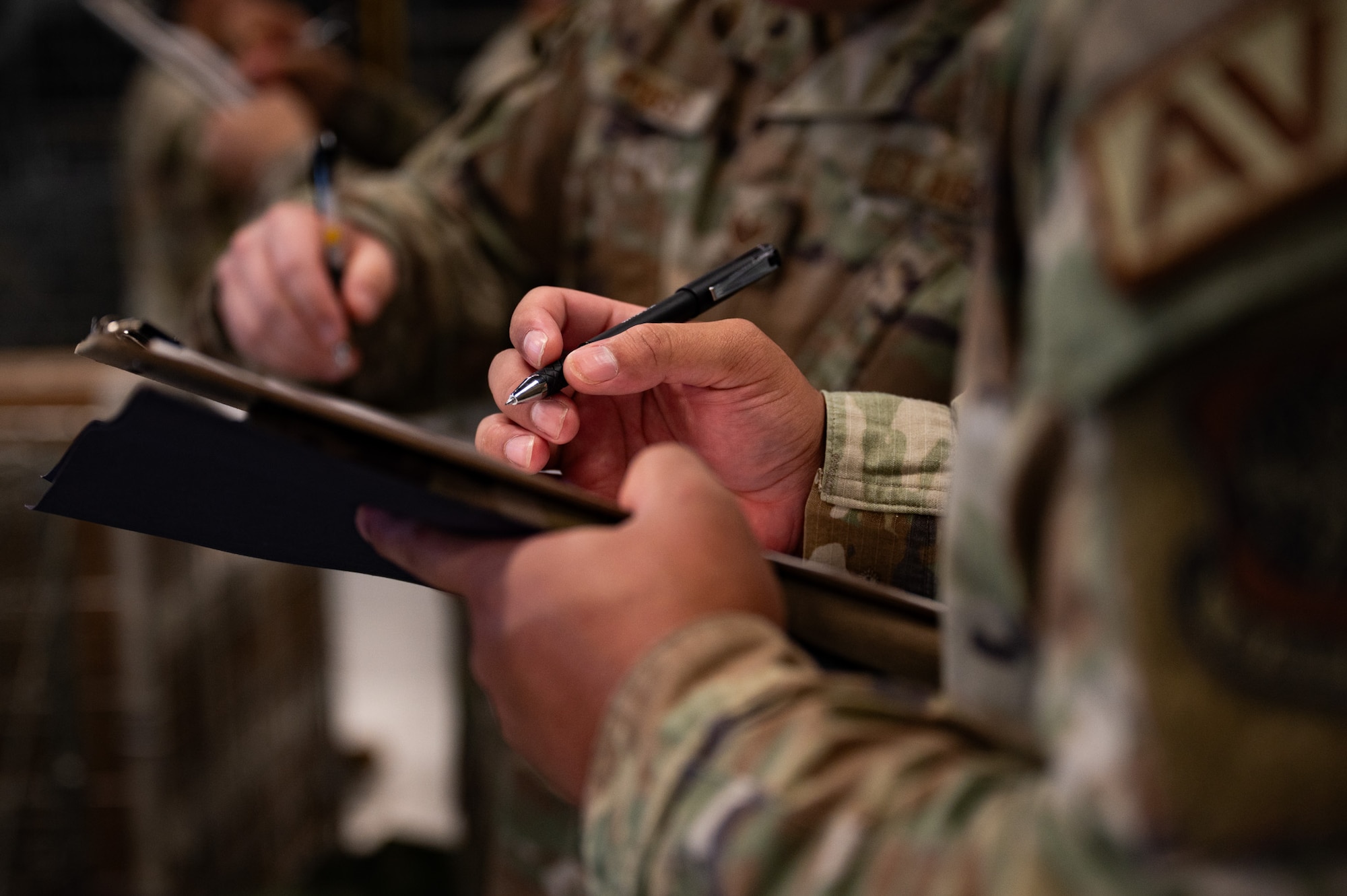 A U.S. Airman fills out a pre-deployment form during a personnel deployment function line at Joint Base McGuire-Dix-Lakehurst, N.J., Aug. 24, 2026. The forms were used to document what specific equipment Airmen were given to ensure when they return, they sign in the correct gear. (U.S. Air Force photo by Airman 1st Class Haeleigh Bayle)