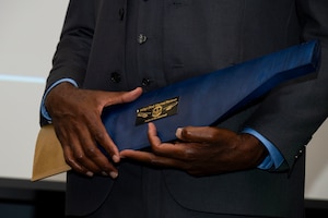 Hands hold an award.