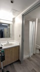 A photo of a renovated bathroom in an Unaccompanied Housing (UH) building – commonly known as barracks – on Naval Base Kitsap-Bremerton. The 10-story, 152-room barracks received full-scale interior renovation and new furnishing following fire and water damage sustained in August 2025. The milestone marks the first of the Navy’s six major sustainment, restoration, and modernization projects funded through the Barracks Task Force to reach completion, directly advancing the Navy’s “No Sailor Living Afloat” initiative – a drive to move Sailors off docked ships and into high-quality shore housing – and the Commander, Navy Installations Command (CNIC) Quality of Service improvement efforts.