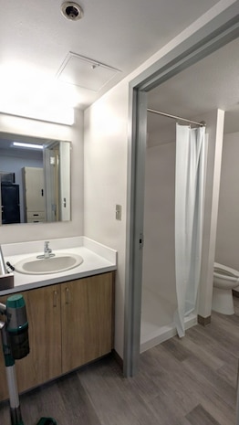 A photo of a renovated bathroom in an Unaccompanied Housing (UH) building – commonly known as barracks – on Naval Base Kitsap-Bremerton. The 10-story, 152-room barracks received full-scale interior renovation and new furnishing following fire and water damage sustained in August 2025. The milestone marks the first of the Navy’s six major sustainment, restoration, and modernization projects funded through the Barracks Task Force to reach completion, directly advancing the Navy’s “No Sailor Living Afloat” initiative – a drive to move Sailors off docked ships and into high-quality shore housing – and the Commander, Navy Installations Command (CNIC) Quality of Service improvement efforts.