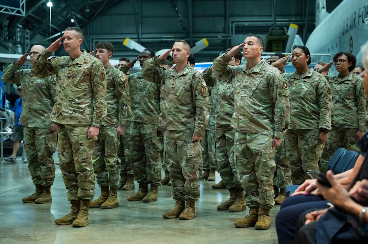 Air Force airmen in camo giving a salute.