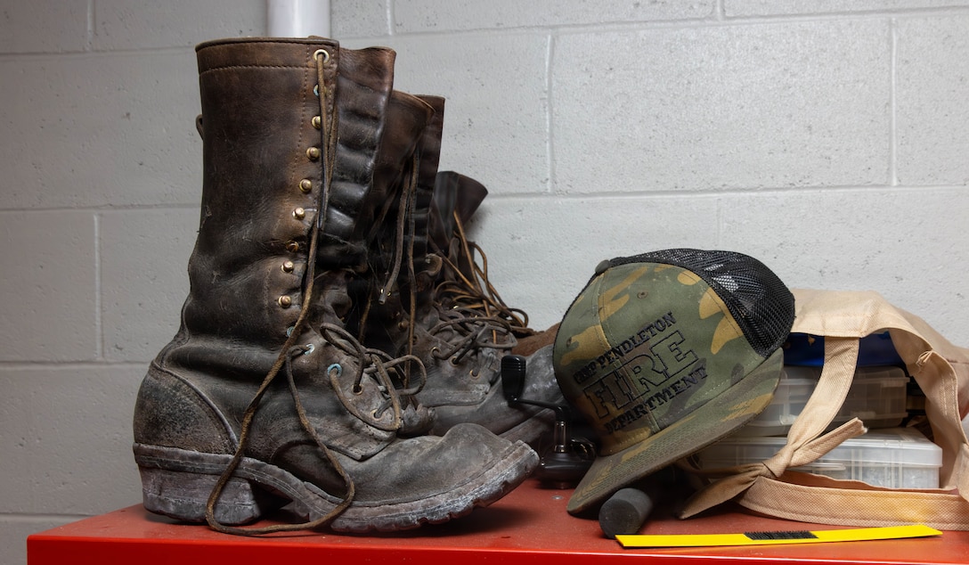 Boots, headgear and supplies sit on top of a locker at Camp Pendleton Fire Station 4 at Marine Corps Base Camp Pendleton, Calif., Aug. 19, 2026. The Camp Pendleton Fire Department has operated since 1942 and comprises over 100 firefighters across 11 stations; it provides wildland fire suppression, advanced life support, emergency medical services, technical rescue, hazmat services and fire prevention and inspection. (U.S. Marine Corps photo by Cpl. Jacqueline Akamelu)