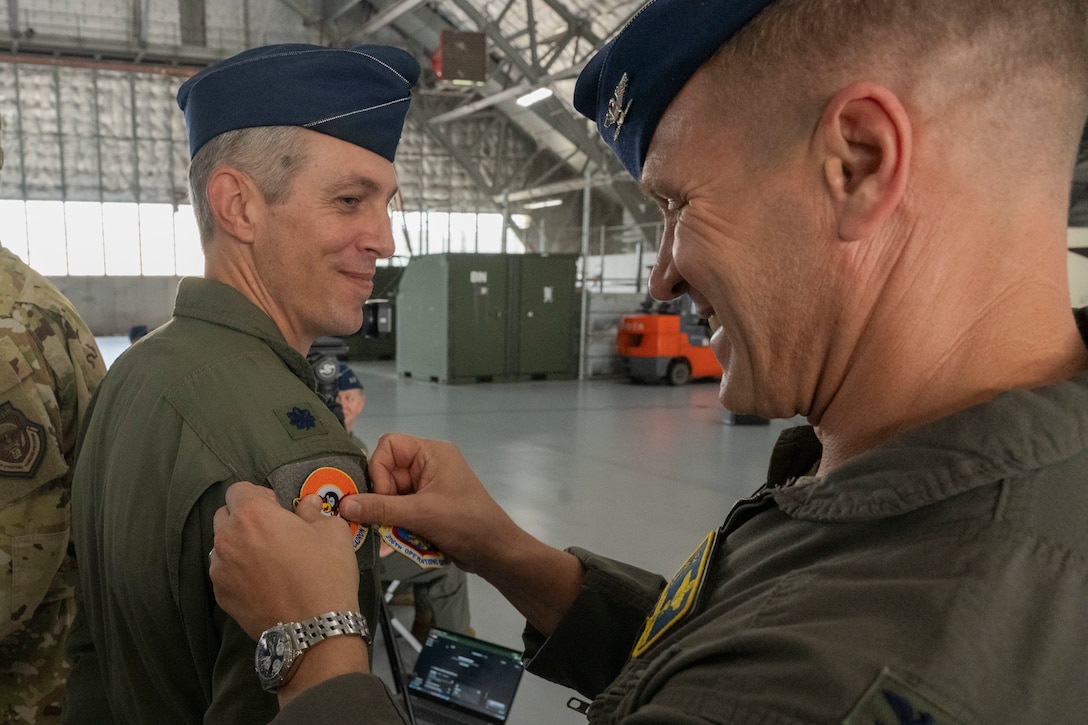 Man puts patch on service member.