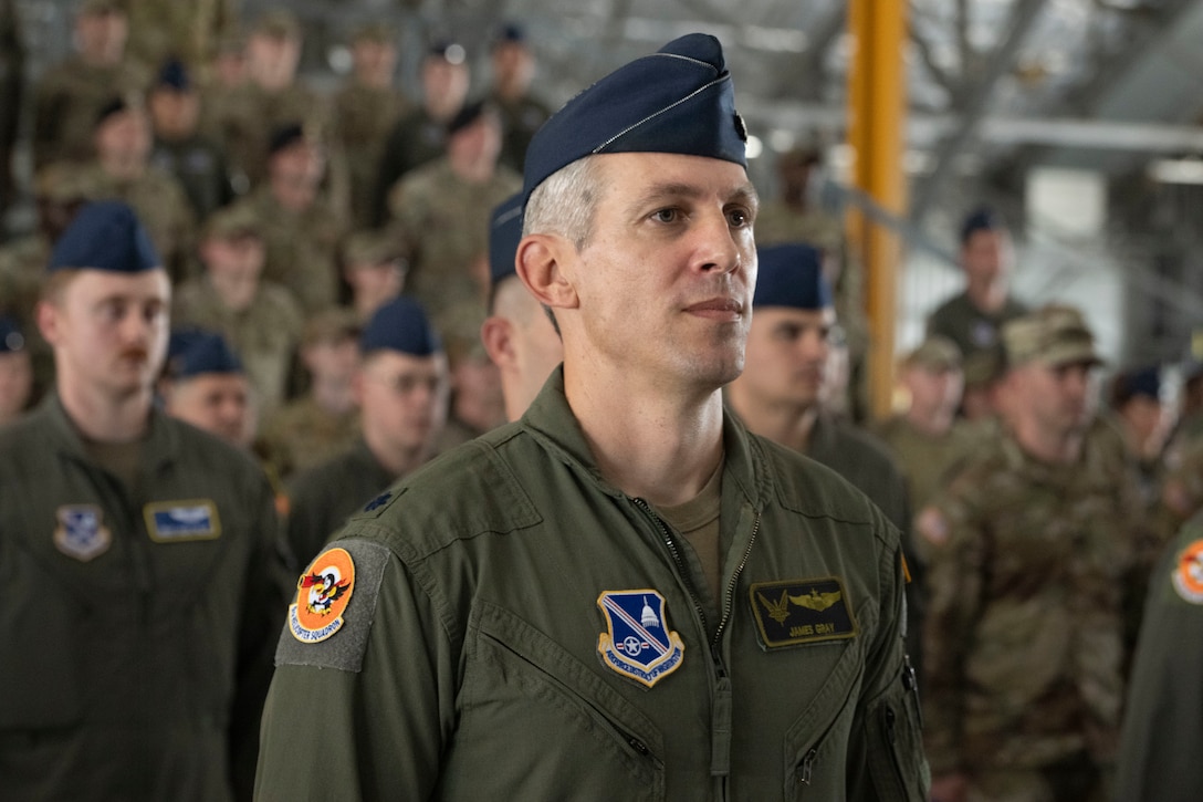 Service members stands at attention.
