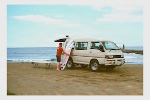 Craig Hale, Nick Pallett’s friend, unloads a surfboard on a beach.