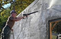 Construction Mechanic Constructionman Mark Davis, assigned to Amphibious Construction Battalion (ACB) 1, uses a pressure-washer to clean an exterior wall as part of a Pacific Partnership 2026 (PP26) engineering project at the Escola Básica Filial Kasnafar schoolhouse in Dili, Timor-Leste, Aug. 20, 2026.