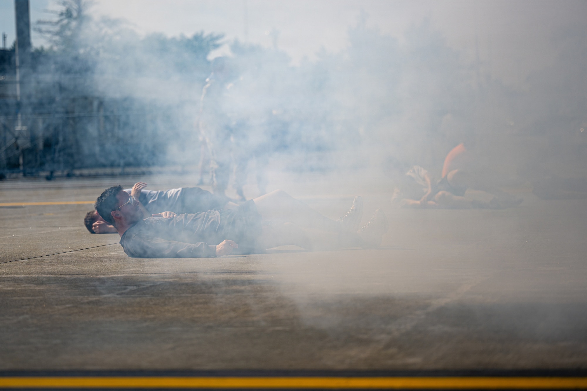 Simulated patients lay down on the flightline during an aircraft mass casualty exercise.