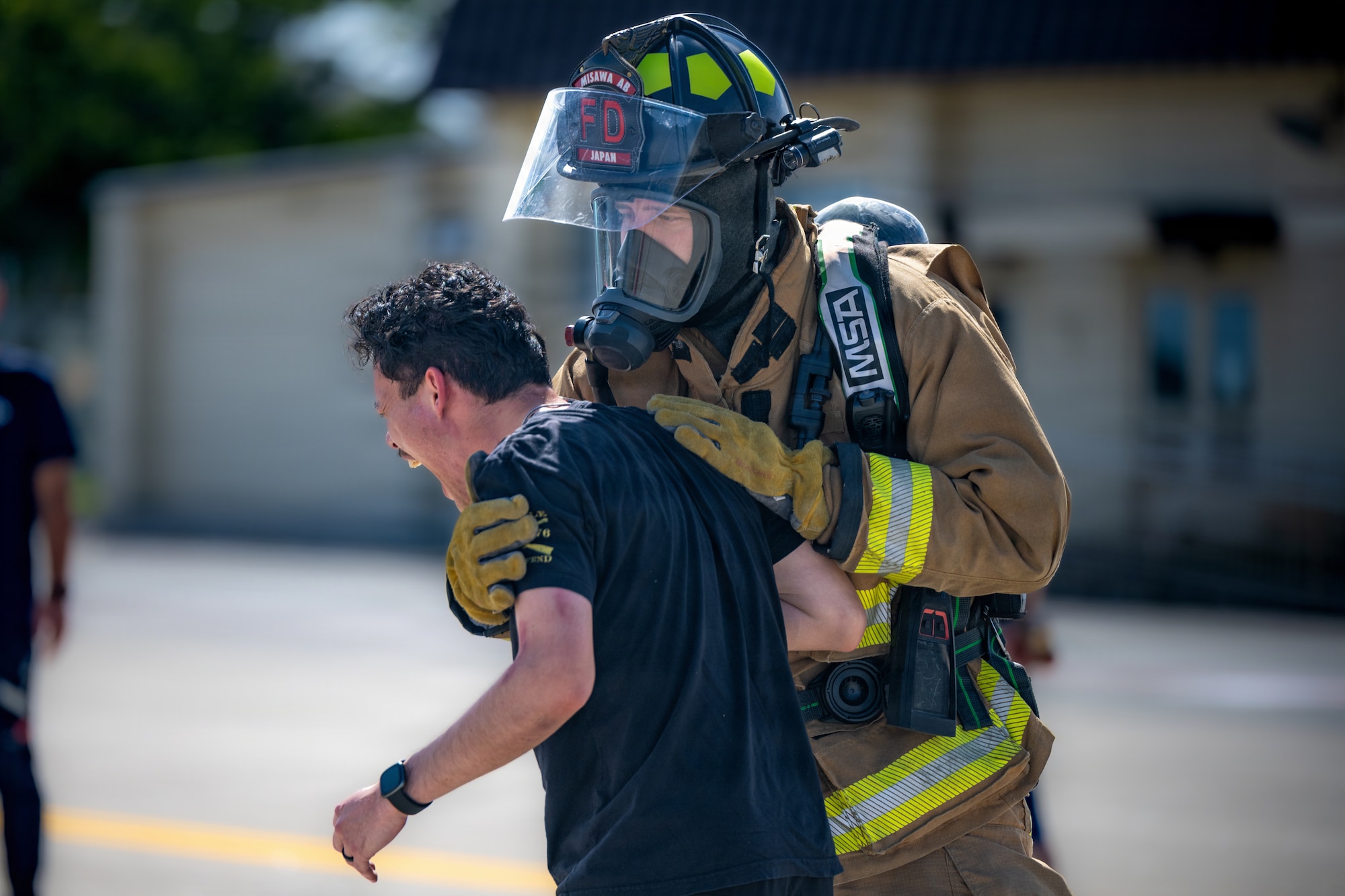 U.S. Air Force Senior Airman Benjamin McEntire, 35th Civil Engineer Squadron firefighter, catches Airman 1st Class Steven Kelly, 35th Comptroller Squadron financial operations technician acting as a simulated hysteric patient, during an aircraft mass casualty exercise.