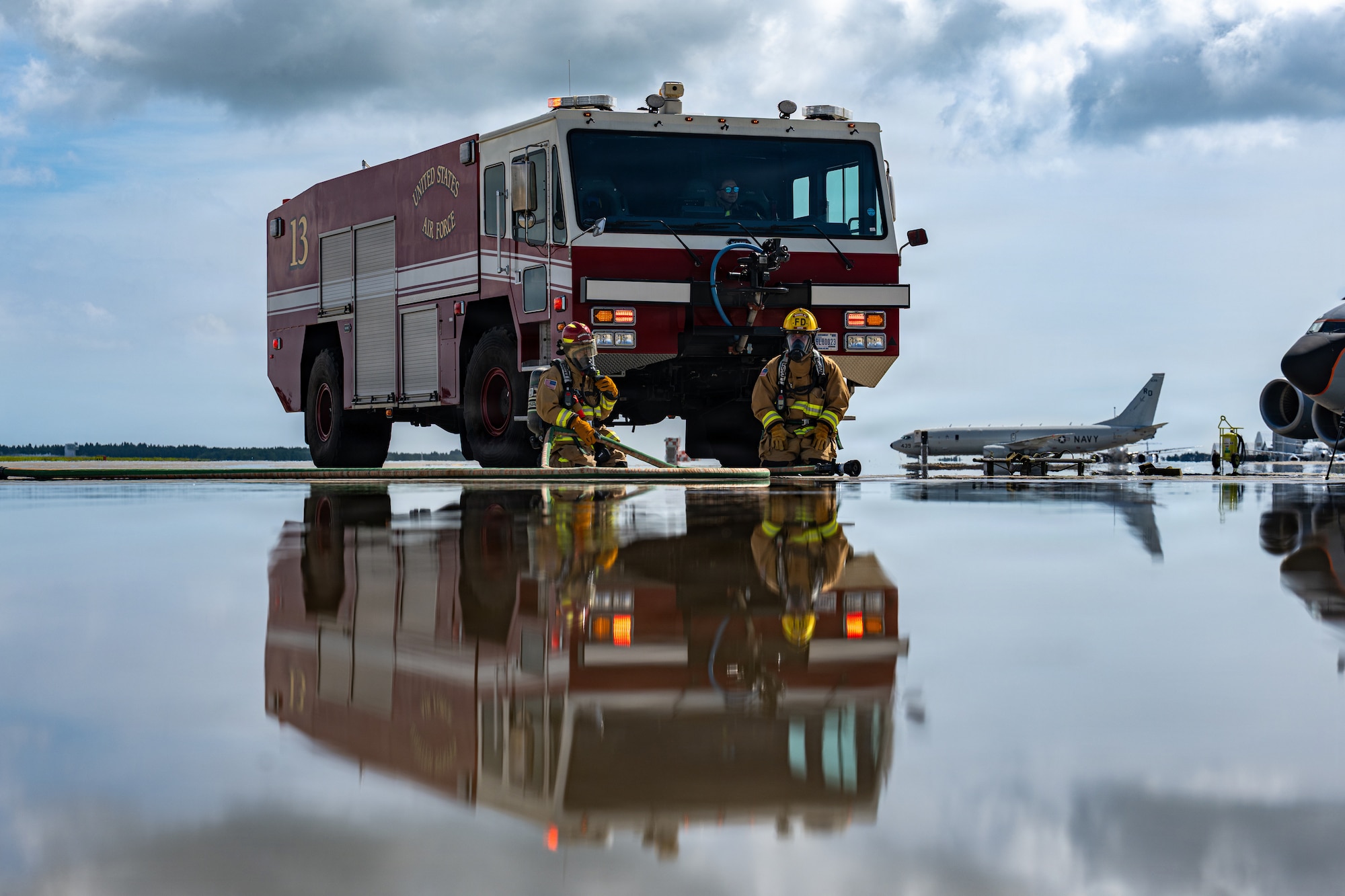 Tadakatsu Kumagai, left, and Migaku Esashika, 35th Fighter Wing Civil Engineer Squadron firefighters, participate in a simulated crashed aircraft during an aircraft mass casualty exercise.