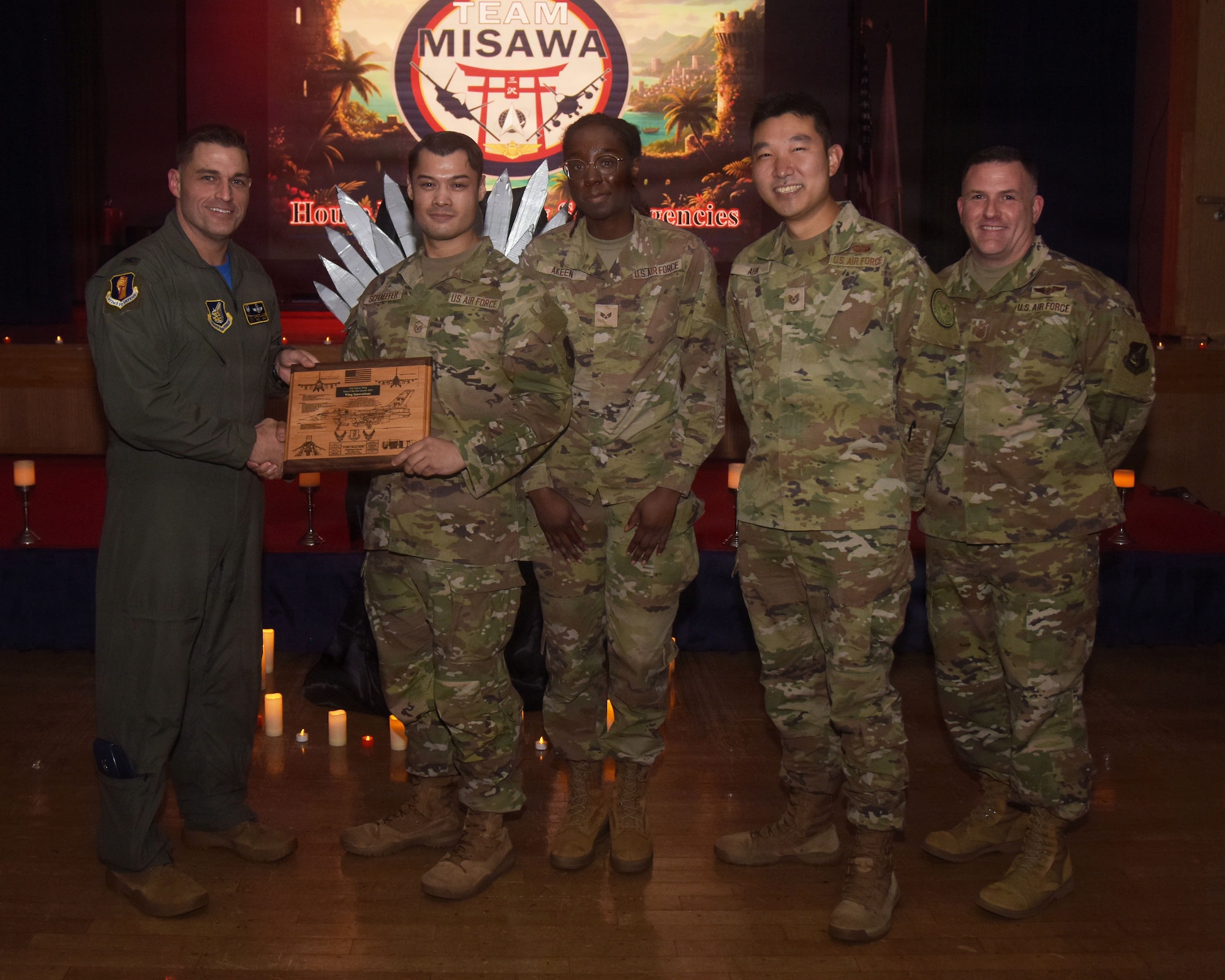 The U.S. Air Force innovation cell team assigned to the 35th Fighter Wing (FW) receives a Team of the Quarter award from Col. Oliver Lause, 35th FW commander, left, and Chief Master Sgt. Jason Amaxopulos, 35 FW command chief, right, during a Wing Quarterly Awards ceremony.
