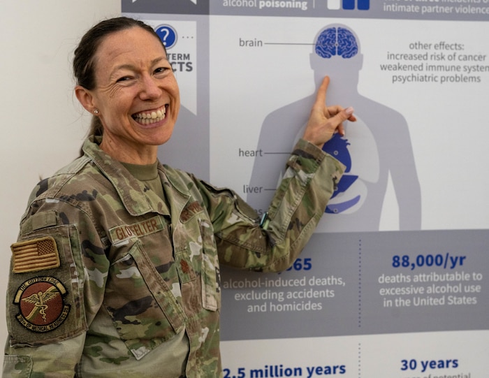 U.S. Air Force Maj. Michael Ann Glotfelter, 39th Medical Group clinical psychologist, points at a graphic of the human body, highlighting the human brain.