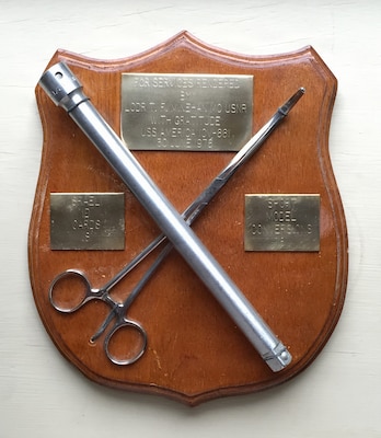 Photograph of a one-of-a-kind award presented to Lt. Cmdr. Tom Minehan, a U.S. Navy Medical Corps officer and general surgeon, for his assistance in extricating a wench that disabled the engine aboard Kitty Hawk-class aircraft carrier USS America (CV 66) in the Mediterranean Sea in 1976. (U.S. Navy photo courtesy of Dr. Tom Minehan)