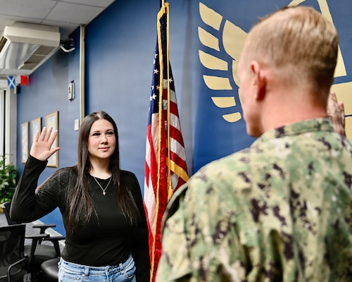Great Lakes, Ill. - Lt. Cmdr. Robert Johnson, Medical Officer Programs and Scholarships officer assigned to Navy Talent Acquisition Group Great Lakes, administers the commissioning oath to Ensign Carina Alers during one of two commissioning ceremonies held that day.